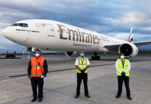 Staff pose in front an EK SkyCargo freighter