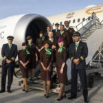 Etihad Airways crew pose in front of an aircraft